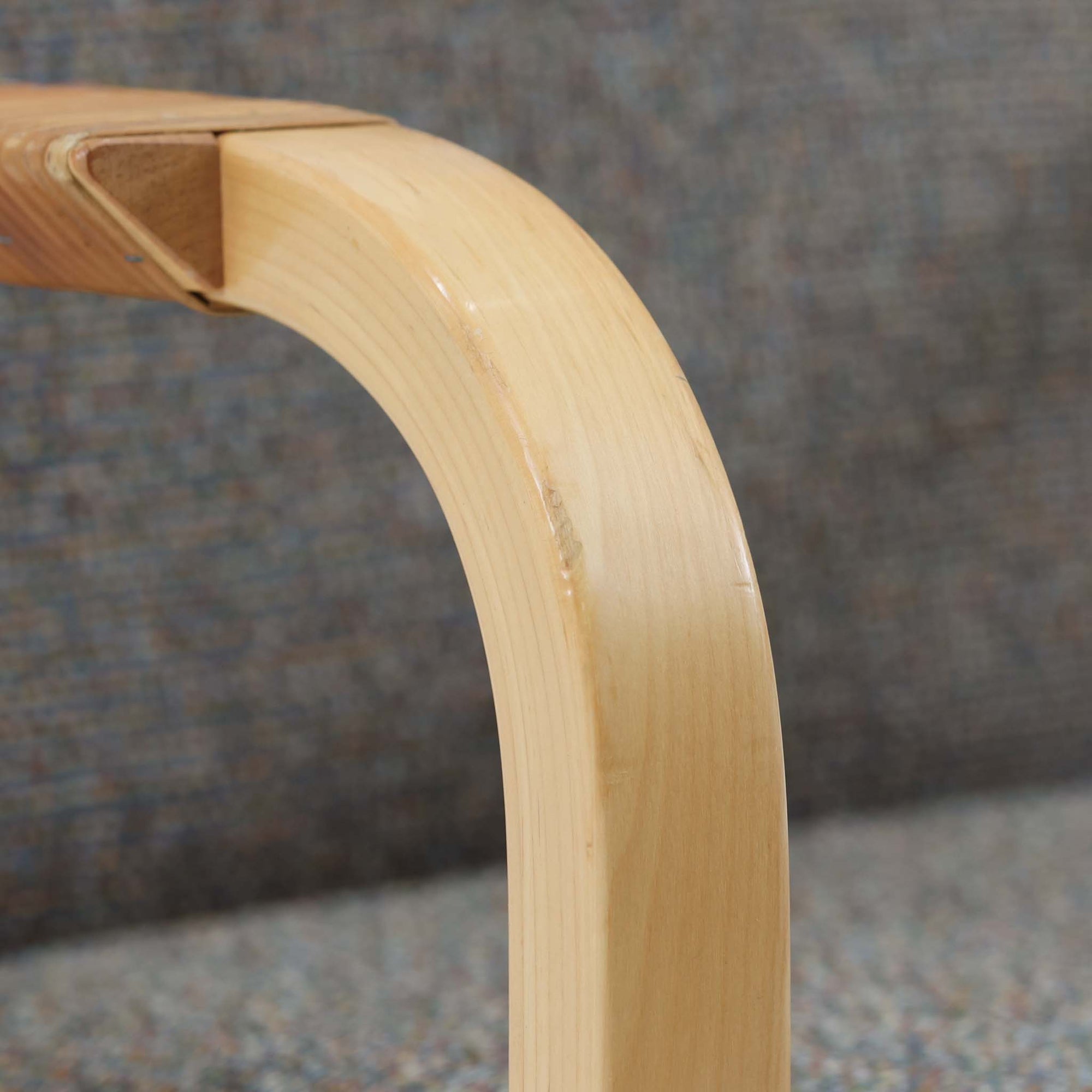 アルヴァ・アアルトが手掛け、アルテックより製作されたモデルE45のアームチェアは、積層バーチ材による滑らかなフレームと、アーム上部に施されたラタン巻きが特徴的な北欧ビンテージの名作です。直線と曲線を巧みに組み合わせた構造は、視覚的な軽やかさと高い強度を両立し、背と座には張りのあるファブリックを用いることで、長時間でも快適な座り心地を実現しています。使い込むほどに木部の色味が深まり、素材の経年変化を楽しめる点も魅力で、ダイニングや書斎、公共空間まで幅広いシーンで活躍する一脚です。