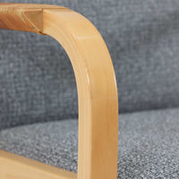 アルヴァ・アアルトが手掛け、アルテックより製作されたモデルE45のアームチェアは、積層バーチ材による滑らかなフレームと、アーム上部に施されたラタン巻きが特徴的な北欧ビンテージの名作です。直線と曲線を巧みに組み合わせた構造は、視覚的な軽やかさと高い強度を両立し、背と座には張りのあるファブリックを用いることで、長時間でも快適な座り心地を実現しています。使い込むほどに木部の色味が深まり、素材の経年変化を楽しめる点も魅力で、ダイニングや書斎、公共空間まで幅広いシーンで活躍する一脚です。