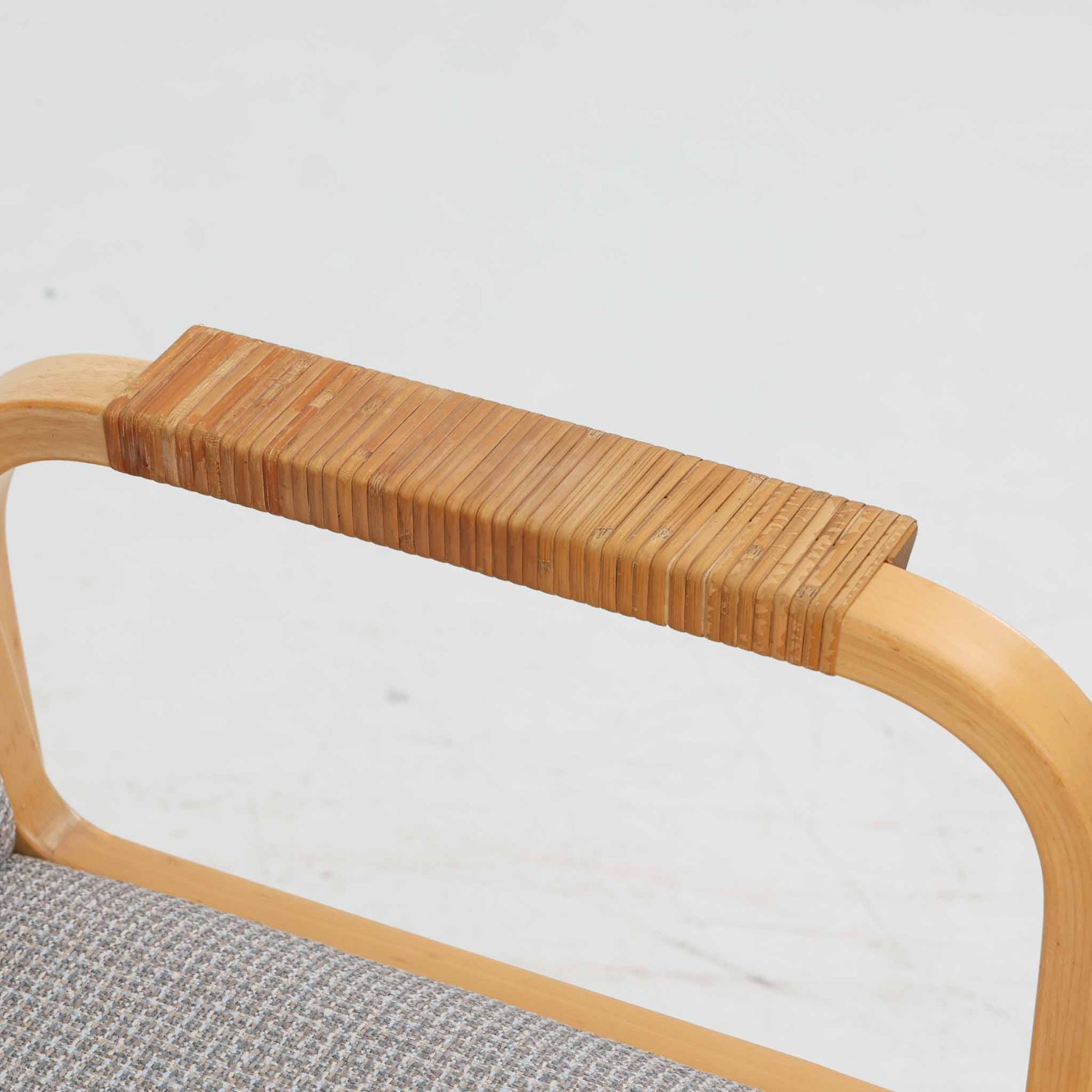 アルヴァ・アアルトが手掛け、アルテックより製作されたモデルE45のアームチェアは、積層バーチ材による滑らかなフレームと、アーム上部に施されたラタン巻きが特徴的な北欧ビンテージの名作です。直線と曲線を巧みに組み合わせた構造は、視覚的な軽やかさと高い強度を両立し、背と座には張りのあるファブリックを用いることで、長時間でも快適な座り心地を実現しています。使い込むほどに木部の色味が深まり、素材の経年変化を楽しめる点も魅力で、ダイニングや書斎、公共空間まで幅広いシーンで活躍する一脚です。