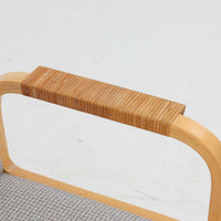 アルヴァ・アアルトが手掛け、アルテックより製作されたモデルE45のアームチェアは、積層バーチ材による滑らかなフレームと、アーム上部に施されたラタン巻きが特徴的な北欧ビンテージの名作です。直線と曲線を巧みに組み合わせた構造は、視覚的な軽やかさと高い強度を両立し、背と座には張りのあるファブリックを用いることで、長時間でも快適な座り心地を実現しています。使い込むほどに木部の色味が深まり、素材の経年変化を楽しめる点も魅力で、ダイニングや書斎、公共空間まで幅広いシーンで活躍する一脚です。