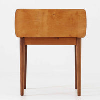 Johannes Andersen（ヨハネス・アンダーセン）がCFC Silkeborgのために手掛けた2段チェストは、チーク材を贅沢に用いた柔らかな曲面フォルムと長く伸びた彫刻的なハンドルが印象的で、天板から側面へと美しくつながる木目が上質な素材感を際立たせる北欧ビンテージ家具です。職人技の光る滑らかな面取りや端正な造りが深い味わいを生み出し、コンパクトながら実用的な2杯の引き出しを備え、ベッドサイドやリビングのサイドテーブルとしても活躍し、温かみのある木肌の経年変化が魅力を一層引き立てています。