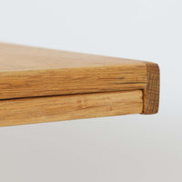 Henning Kjaernulfがデザインし、Nyrup Mobelfabrikが手掛けたエクステンションダイニングテーブルです。オーク材ならではの力強い木目と経年で深みを増した色艶が魅力で、X字状の脚部や波状に削り出された貫が北欧らしい素朴さと彫刻的な美しさを演出しています。左右の天板を引き出すことで幅251cmまで拡張可能な実用的構造で、日常使いから来客時まで幅広く活躍。重厚感がありながらも軽やかな意匠にまとめられた、希少性の高い北欧ビンテージ家具です。
