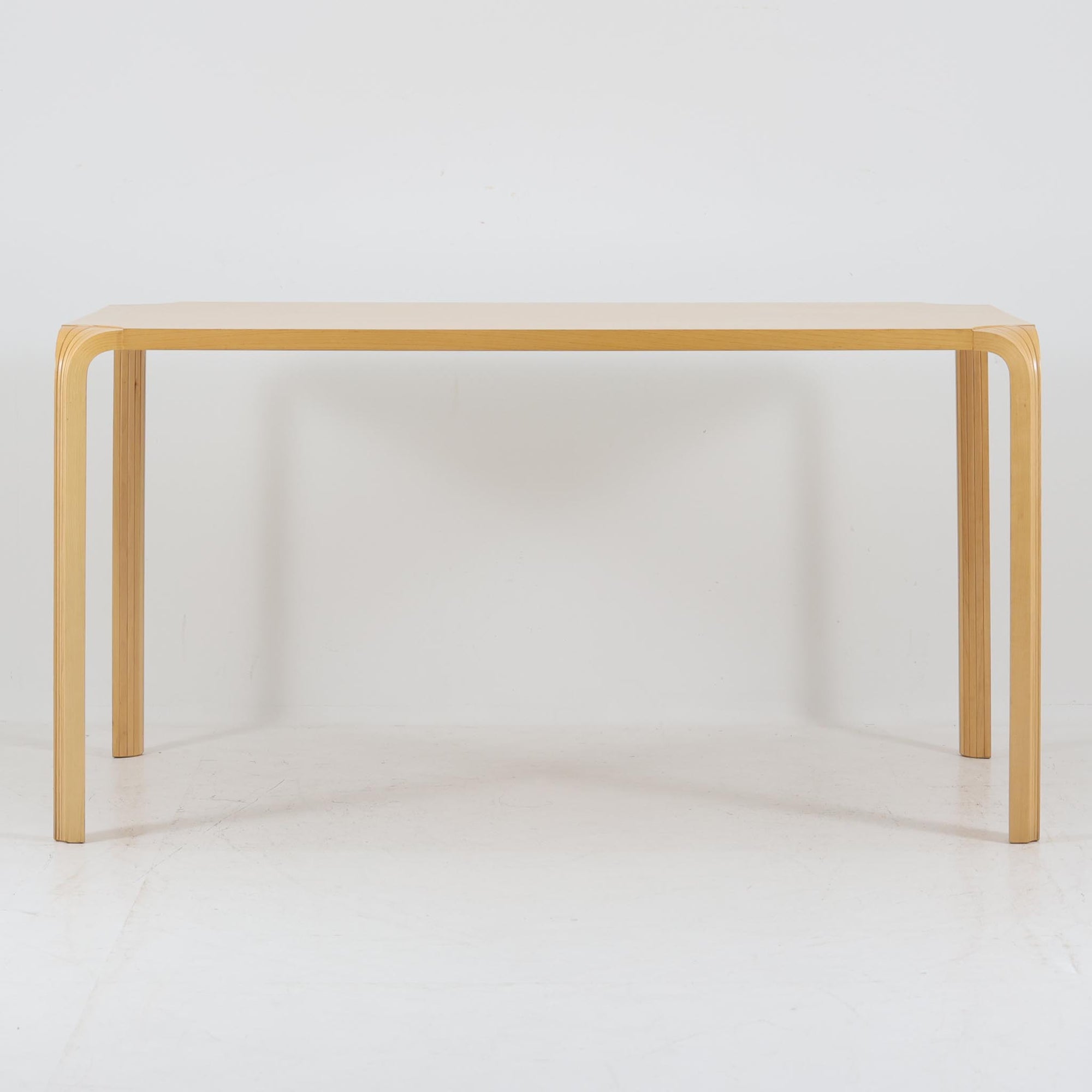 フィンランドを代表する建築家アルヴァ・アアルトによるデザイン、Artek社製の「X-leg」ダイニングテーブルです。素材には温かみのあるバーチ材を使用し、アアルトの象徴でもある積層合板による柔らかな曲線脚が特徴です。角のない優しいフォルムとシンプルな構造美が調和し、北欧デザインの真髄を感じさせます。経年によるバーチ材の飴色の風合いが美しく、空間に軽やかで穏やかな印象を与える一台です。