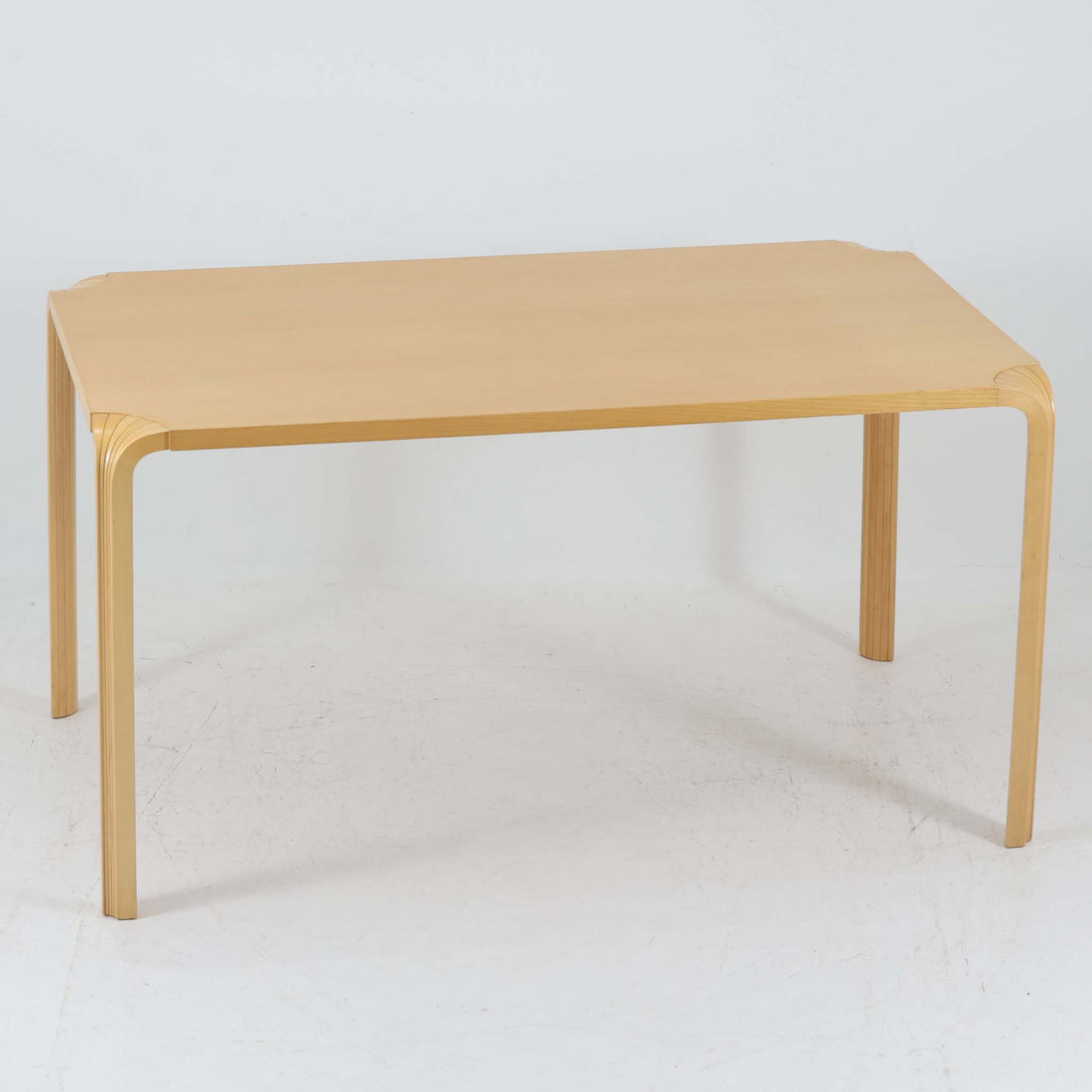 フィンランドを代表する建築家アルヴァ・アアルトによるデザイン、Artek社製の「X-leg」ダイニングテーブルです。素材には温かみのあるバーチ材を使用し、アアルトの象徴でもある積層合板による柔らかな曲線脚が特徴です。角のない優しいフォルムとシンプルな構造美が調和し、北欧デザインの真髄を感じさせます。経年によるバーチ材の飴色の風合いが美しく、空間に軽やかで穏やかな印象を与える一台です。