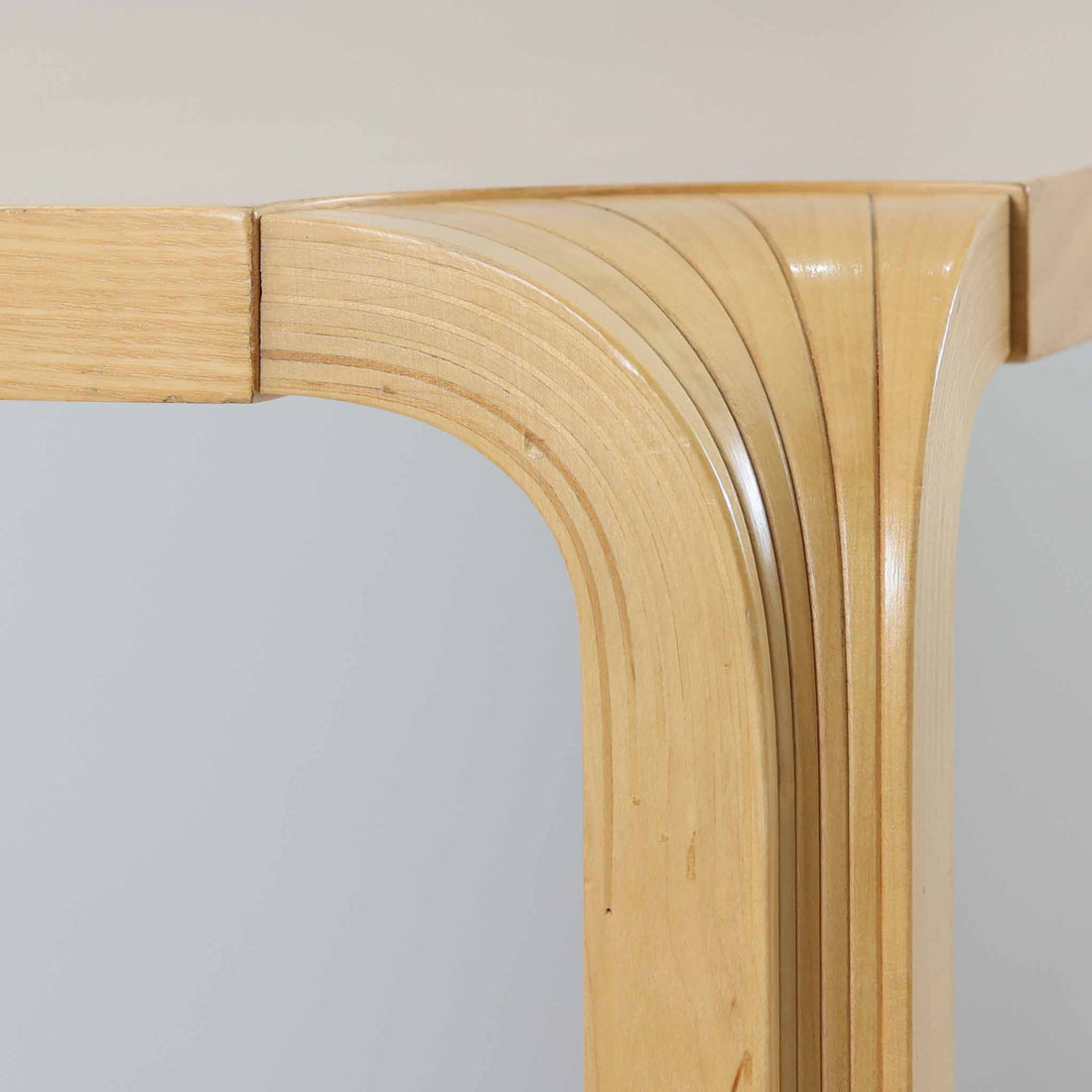 フィンランドを代表する建築家アルヴァ・アアルトによるデザイン、Artek社製の「X-leg」ダイニングテーブルです。素材には温かみのあるバーチ材を使用し、アアルトの象徴でもある積層合板による柔らかな曲線脚が特徴です。角のない優しいフォルムとシンプルな構造美が調和し、北欧デザインの真髄を感じさせます。経年によるバーチ材の飴色の風合いが美しく、空間に軽やかで穏やかな印象を与える一台です。