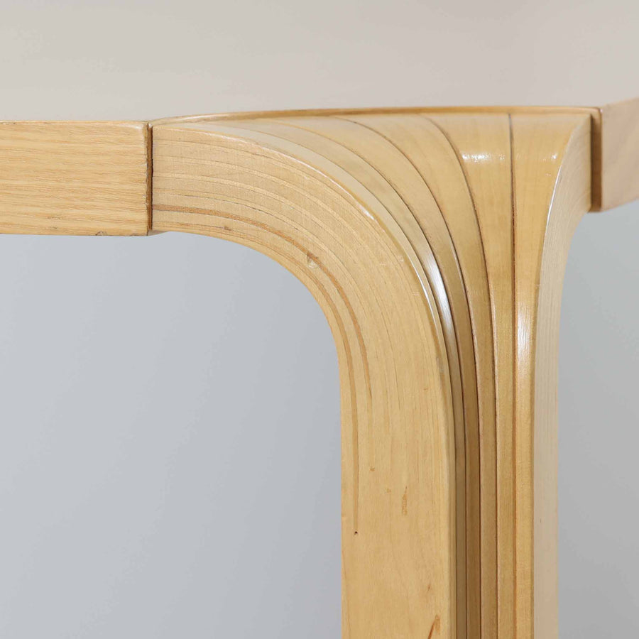 フィンランドを代表する建築家アルヴァ・アアルトによるデザイン、Artek社製の「X-leg」ダイニングテーブルです。素材には温かみのあるバーチ材を使用し、アアルトの象徴でもある積層合板による柔らかな曲線脚が特徴です。角のない優しいフォルムとシンプルな構造美が調和し、北欧デザインの真髄を感じさせます。経年によるバーチ材の飴色の風合いが美しく、空間に軽やかで穏やかな印象を与える一台です。