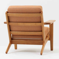 Hans J. Wegnerがデザインし、Getama社によって製作されたGE290は、構造の美しさと快適な座り心地を兼ね備えた北欧ビンテージを代表するシングルソファです。厚みのあるクッションと緩やかに傾斜した背もたれが身体を包み込み、自然と深いリラックス姿勢へと導きます。クッション内部にはビンテージ品ならではのスプリングが内包されており、しっかりとした弾力と安定感のある座り心地を生み出しています。オーク材のフレームは力強さと温かみを併せ持ち、アームから脚部にかけての造形にはウェグナーらしい彫刻的な魅力が感じられます。張地の落ち着いた色合いと、経年により深みを増した木部の表情が調和し、リビングや書斎で長く寄り添う一脚です。
