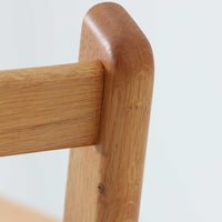 Hans J. Wegnerがデザインし、Getama社によって製作されたGE290は、構造の美しさと快適な座り心地を兼ね備えた北欧ビンテージを代表するシングルソファです。厚みのあるクッションと緩やかに傾斜した背もたれが身体を包み込み、自然と深いリラックス姿勢へと導きます。クッション内部にはビンテージ品ならではのスプリングが内包されており、しっかりとした弾力と安定感のある座り心地を生み出しています。オーク材のフレームは力強さと温かみを併せ持ち、アームから脚部にかけての造形にはウェグナーらしい彫刻的な魅力が感じられます。張地の落ち着いた色合いと、経年により深みを増した木部の表情が調和し、リビングや書斎で長く寄り添う一脚です。