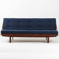 Poul M. Voltherによってデザインされたデイベッドは、機能性と美しさを兼ね備えたビンテージ家具です。ソファとしての使用はもちろん、背もたれを倒すことでリラックスできるベッドとしても使用でき、用途に応じて柔軟に活躍します。フレームにはアフロモシア材が使用されており、深みのある木目と上質な質感が空間に落ち着いた存在感を与えます。アフロモシア材仕様のモデルは流通数が少なく、希少性の高い点も魅力のひとつです。スラット構造による安定感のあるフレームに加え、クッション内部にはスプリングが内包されており、快適な座り心地と寝心地を提供してくれる一台です。