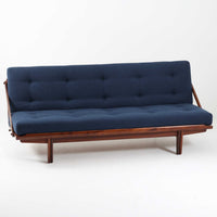 Poul M. Voltherによってデザインされたデイベッドは、機能性と美しさを兼ね備えたビンテージ家具です。ソファとしての使用はもちろん、背もたれを倒すことでリラックスできるベッドとしても使用でき、用途に応じて柔軟に活躍します。フレームにはアフロモシア材が使用されており、深みのある木目と上質な質感が空間に落ち着いた存在感を与えます。アフロモシア材仕様のモデルは流通数が少なく、希少性の高い点も魅力のひとつです。スラット構造による安定感のあるフレームに加え、クッション内部にはスプリングが内包されており、快適な座り心地と寝心地を提供してくれる一台です。