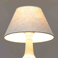 スーホルム・セラミック（Soholm Keramik）によるこちらのテーブルランプは、温かみのある陶磁器ベースに柔らかなブラウンとブルーで描かれた連続模様が印象的で、どこか手仕事の息づかいを感じさせる北欧ビンテージらしい魅力を備えています。丸みを帯びたベースからすっと伸びる首部のラインが美しく、リネンシェードを通した穏やかな灯りが空間にやさしい陰影を生み出します。高さ35cmと日常使いしやすいサイズで、ベッドサイドやリビングのサイドテーブルにも程よく収まり、落ち着いたインテリアに自然に馴染む一台です。