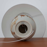 Soholm Keramik（スーホルム・セラミック）が手掛けたこちらのテーブルランプは、淡いグレーを基調にブラウンの流れるような釉薬模様が美しく広がる有機的な表情が魅力で、丸みを帯びた陶磁器のベースが空間にやさしい存在感をもたらす北欧ビンテージ品です。リネンシェードを透ける柔らかな灯りが落ち着いた雰囲気をつくり、ベッドサイドやリビングの間接照明として取り入れやすく、経年によって深まった色合いと一点物ならではの味わいを長く楽しめる一台です。