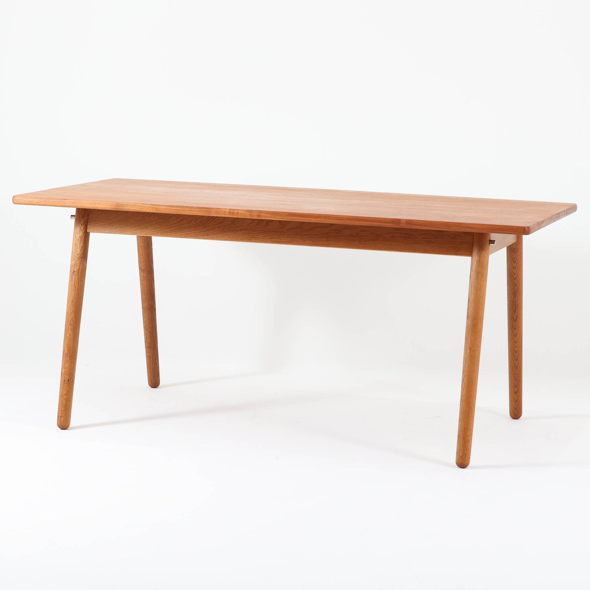 Poul M. Voltherがデザインし、FDB Moblerによって製作された片袖デスク。チーク材の天板と収納部、オーク材の脚部を組み合わせた構成に、真鍮の金具がさりげないアクセントを添える北欧ビンテージらしい一台です。幅160cmのゆとりあるサイズ感に対して、脚部や幕板は軽やかに設計されており、空間に圧迫感を与えません。片側に備えた引き出しユニットは、取り付けた状態でもスライドさせて位置調整が可能で、左右どちら側にも付け替えられる柔軟な構造となっています。さらに引き出しを取り外すことで、デスクとしてだけでなくダイニングテーブルとしても使用でき、暮らしの変化に合わせた使い方ができる点も魅力です。素材ごとの質感の違いと、経年により深みを増した木肌の表情が調和した、長く使い続けたくなるデザインです。