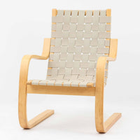 Alvar Aaltoがデザインし、Artekより製作されたNo.406アームチェアです。しなやかな曲線を描くバーチ材の成形フレームが特徴で、浮遊感のあるフォルムと軽やかな佇まいが空間に北欧らしい美しさをもたらします。座面と背もたれにはウェビングテープが張られ、適度な弾力と通気性の良い快適な座り心地を実現。アアルトの有機的なデザイン思想が感じられる一脚で、リビングやラウンジでの寛ぎの時間を彩るビンテージチェアです。