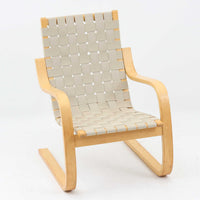 Alvar Aaltoがデザインし、Artekより製作されたNo.406アームチェアです。しなやかな曲線を描くバーチ材の成形フレームが特徴で、浮遊感のあるフォルムと軽やかな佇まいが空間に北欧らしい美しさをもたらします。座面と背もたれにはウェビングテープが張られ、適度な弾力と通気性の良い快適な座り心地を実現。アアルトの有機的なデザイン思想が感じられる一脚で、リビングやラウンジでの寛ぎの時間を彩るビンテージチェアです。