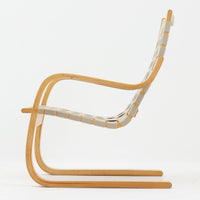 Alvar Aaltoがデザインし、Artekより製作されたNo.406アームチェアです。しなやかな曲線を描くバーチ材の成形フレームが特徴で、浮遊感のあるフォルムと軽やかな佇まいが空間に北欧らしい美しさをもたらします。座面と背もたれにはウェビングテープが張られ、適度な弾力と通気性の良い快適な座り心地を実現。アアルトの有機的なデザイン思想が感じられる一脚で、リビングやラウンジでの寛ぎの時間を彩るビンテージチェアです。