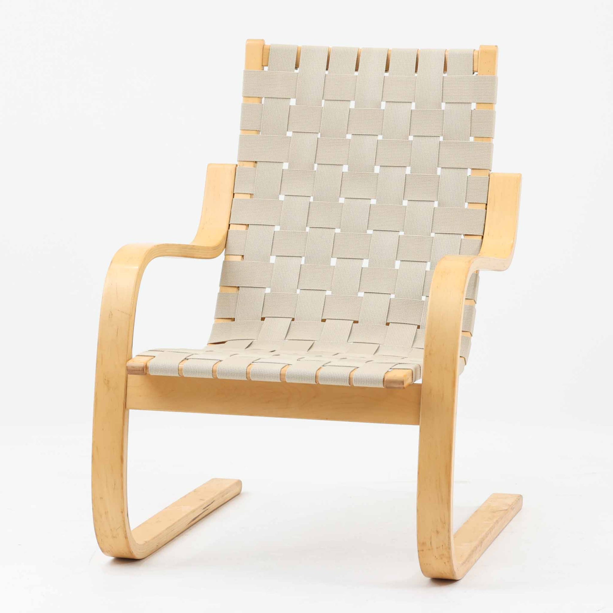 Alvar Aaltoがデザインし、Artekより製作されたNo.406アームチェアです。しなやかな曲線を描くバーチ材の成形フレームが特徴で、浮遊感のあるフォルムと軽やかな佇まいが空間に北欧らしい美しさをもたらします。本品は1996年製の個体で、ビンテージならではの雰囲気をお楽しみいただけます。座面と背もたれにはウェビングテープが張られ、適度な弾力と通気性の良い快適な座り心地を実現。アアルトの有機的なデザイン思想が感じられる一脚で、リビングやラウンジでの寛ぎの時間を彩るビンテージチェアです。