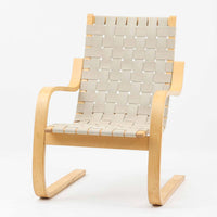 Alvar Aaltoがデザインし、Artekより製作されたNo.406アームチェアです。しなやかな曲線を描くバーチ材の成形フレームが特徴で、浮遊感のあるフォルムと軽やかな佇まいが空間に北欧らしい美しさをもたらします。本品は1996年製の個体で、ビンテージならではの雰囲気をお楽しみいただけます。座面と背もたれにはウェビングテープが張られ、適度な弾力と通気性の良い快適な座り心地を実現。アアルトの有機的なデザイン思想が感じられる一脚で、リビングやラウンジでの寛ぎの時間を彩るビンテージチェアです。