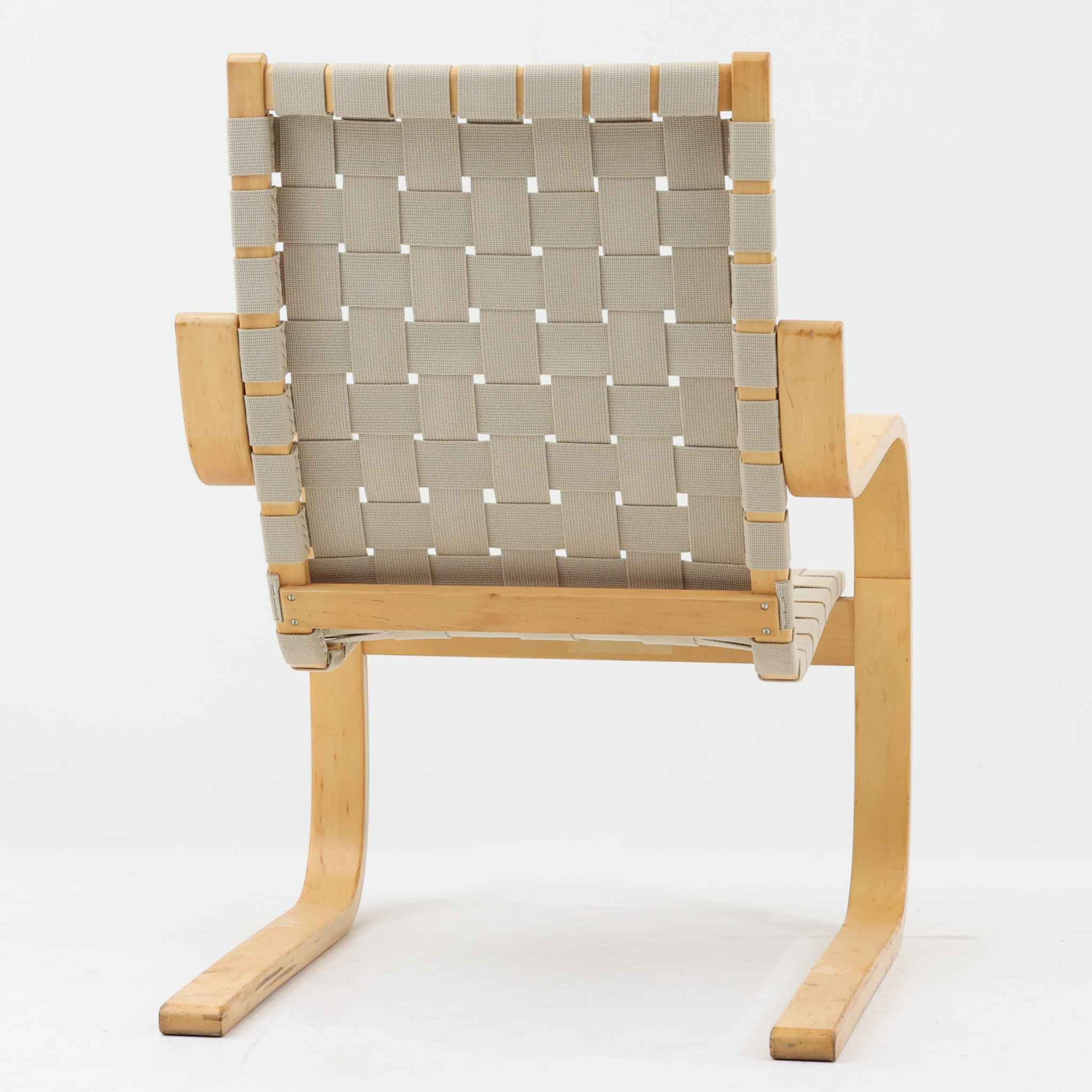 Alvar Aaltoがデザインし、Artekより製作されたNo.406アームチェアです。しなやかな曲線を描くバーチ材の成形フレームが特徴で、浮遊感のあるフォルムと軽やかな佇まいが空間に北欧らしい美しさをもたらします。本品は1996年製の個体で、ビンテージならではの雰囲気をお楽しみいただけます。座面と背もたれにはウェビングテープが張られ、適度な弾力と通気性の良い快適な座り心地を実現。アアルトの有機的なデザイン思想が感じられる一脚で、リビングやラウンジでの寛ぎの時間を彩るビンテージチェアです。