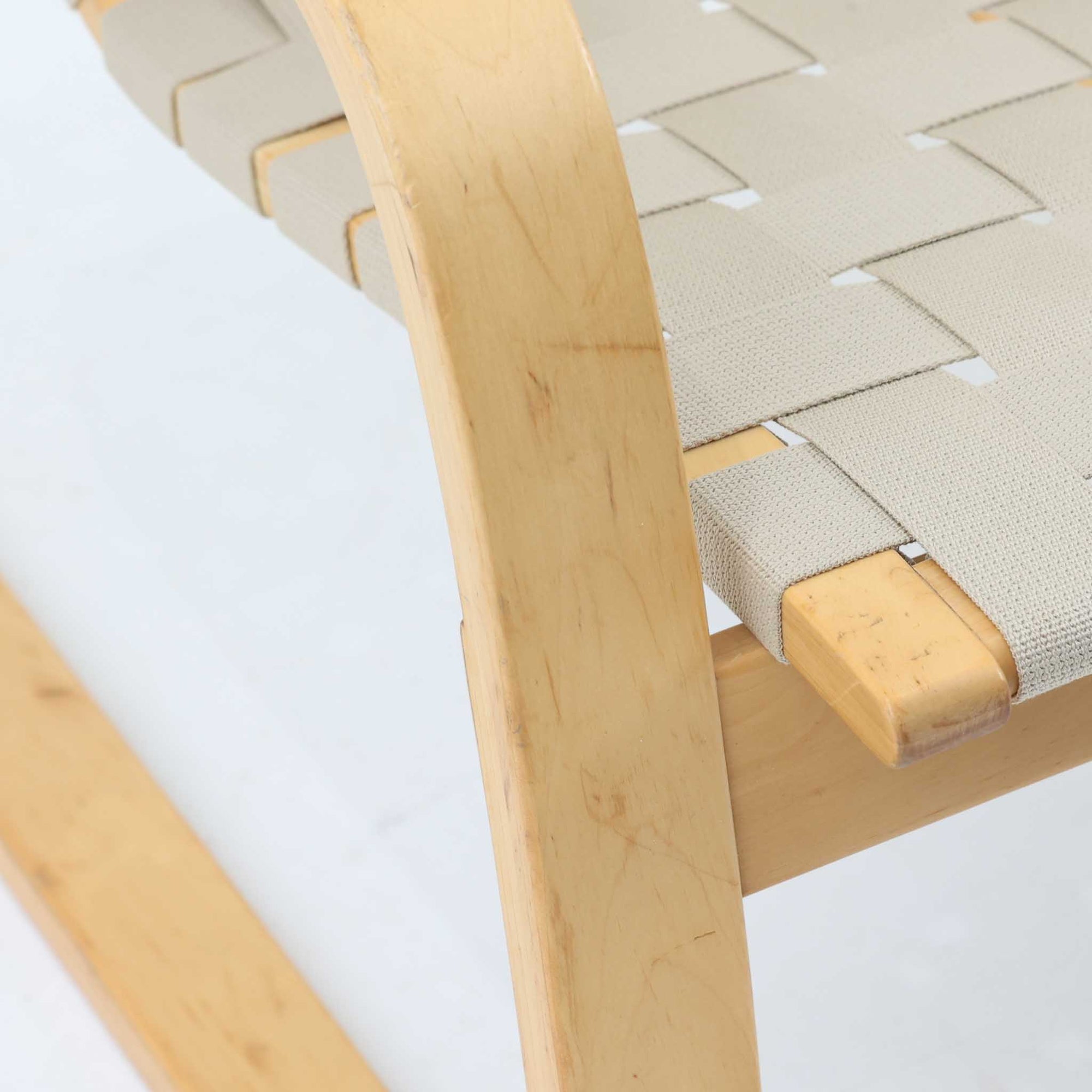 Alvar Aaltoがデザインし、Artekより製作されたNo.406アームチェアです。しなやかな曲線を描くバーチ材の成形フレームが特徴で、浮遊感のあるフォルムと軽やかな佇まいが空間に北欧らしい美しさをもたらします。本品は1996年製の個体で、ビンテージならではの雰囲気をお楽しみいただけます。座面と背もたれにはウェビングテープが張られ、適度な弾力と通気性の良い快適な座り心地を実現。アアルトの有機的なデザイン思想が感じられる一脚で、リビングやラウンジでの寛ぎの時間を彩るビンテージチェアです。