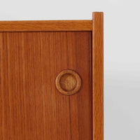 スウェーデン製のこちらのオープンシェルフは、チーク材の温かな木目とオーク材の脚部を組み合わせた軽やかな佇まいが魅力で、上段の棚板と下段のスライド扉収納を備えた実用性の高い構成が特徴の北欧ビンテージ家具です。丸い掘り込み取手や細身のフレームなど繊細なディテールが空間を柔らかく彩り、本や雑貨、食器などを美しく見せながら整頓でき、経年で深まった木肌の風合いがインテリアに落ち着きと温もりを与える一台です。