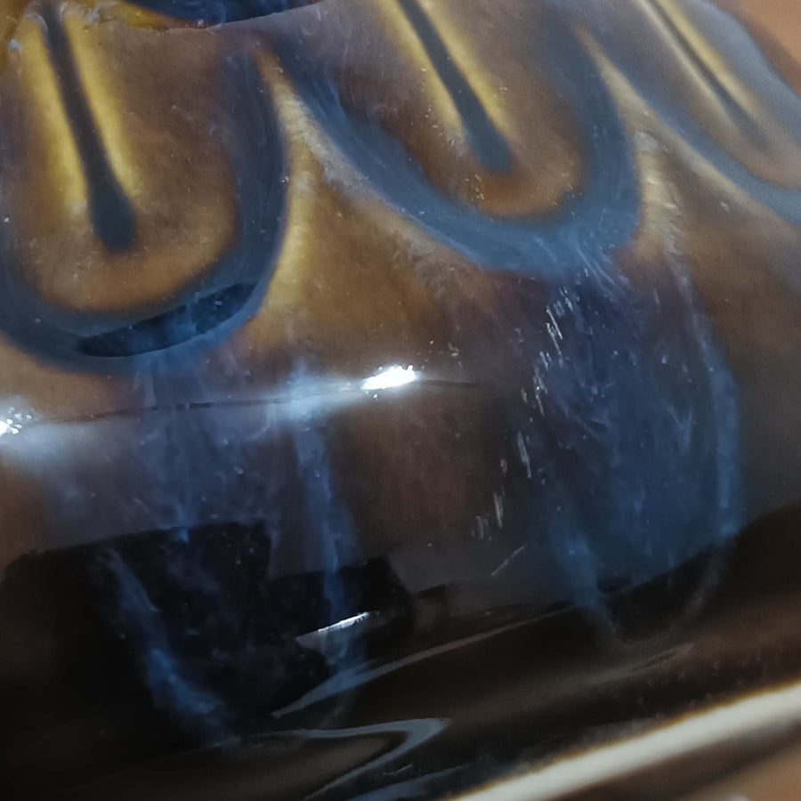 Einar JohansenがSoholm Keramik（スーホルム・セラミック）のために手掛けたモデル1015は、深いブラウンの釉薬に美しい光沢が宿り、ベースを覆う羽根模様のようなレリーフが立体的な表情を生み出す北欧ビンテージの名品で、すっきりと立ち上がるシルエットと陶磁器ならではの重厚感が空間に落ち着いた存在感をもたらします。リネンシェードを通したやわらかな灯りはベッドサイドやリビングに 温かみを添え、経年の風合いが一点物としての魅力をより一層引き立てています。