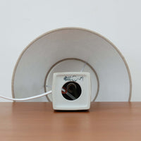 Nils Thorsson（ニルス・トールソン）がRoyal Copenhagen（ロイヤルコペンハーゲン）のために手掛けた「BACA」シリーズのテーブルランプは、繊細な線描と象徴的なモチーフが幾何学的に配置された陶磁器ベースが特徴で、手仕事ならではの奥行きあるブラウンの釉調がビンテージとしての存在感を高めています。上下で形状が切り替わる立体的な構造が光を受けて表情を変え、リネンシェードを通した柔らかな灯りが空間に落ち着いた陰影を添えます。高さ36cmの扱いやすいサイズで、リビングや寝室のサイドテーブルにもよく馴染み、北欧デザインの芸術性と実用性を兼ね備えた一台です。