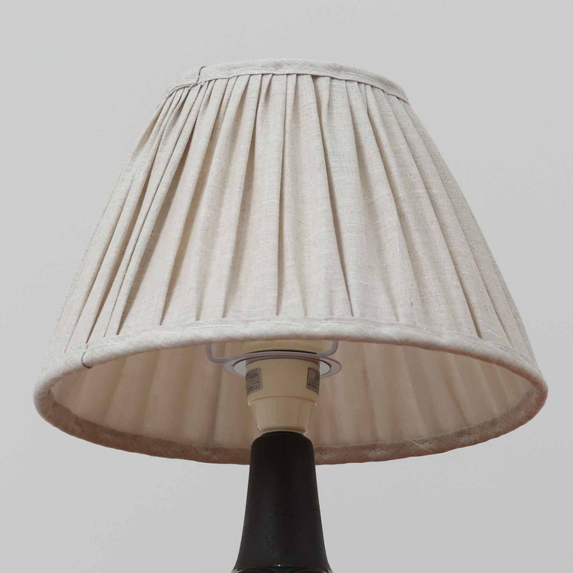 Einar JohansenがSoholm Keramik（スーホルム・セラミック）のためにデザインしたモデル1031は、深みのあるブルーの釉薬と立体的な面取りが織りなす陰影が美しい陶磁器ベースが特徴で、上部のマットな質感との対比がモダンで彫刻的な存在感を放つ北欧ビンテージ品です。プリーツシェードを透ける柔らかな灯りが落ち着いた雰囲気をつくり、ベッドサイドやリビングのアクセント照明として取り入れやすく、経年で深まった釉薬の表情が一点物ならではの魅力を一層引き立てています。