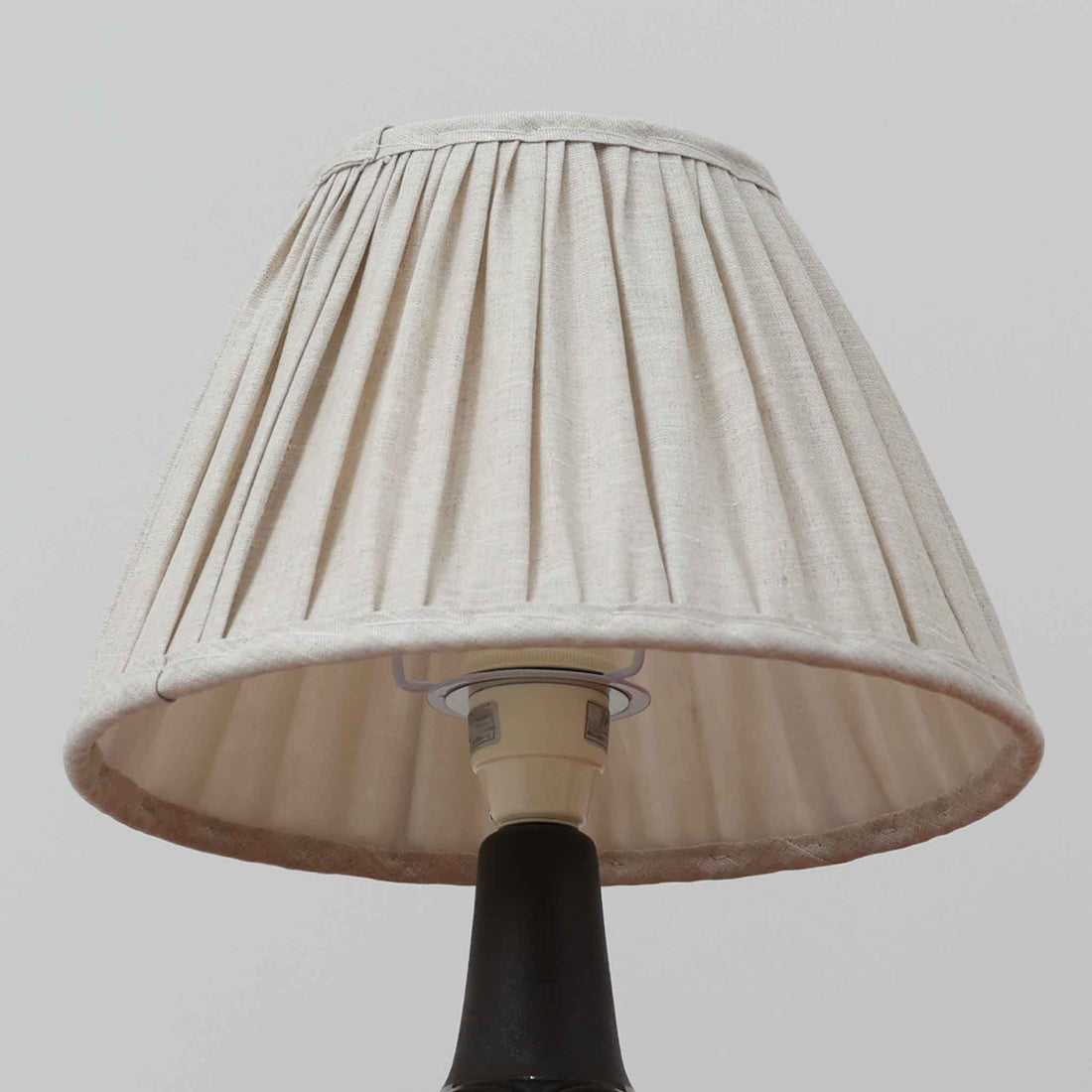 Einar JohansenがSoholm Keramik（スーホルム・セラミック）のためにデザインしたモデル1031は、深みのあるブルーの釉薬と立体的な面取りが織りなす陰影が美しい陶磁器ベースが特徴で、上部のマットな質感との対比がモダンで彫刻的な存在感を放つ北欧ビンテージ品です。プリーツシェードを透ける柔らかな灯りが落ち着いた雰囲気をつくり、ベッドサイドやリビングのアクセント照明として取り入れやすく、経年で深まった釉薬の表情が一点物ならではの魅力を一層引き立てています。