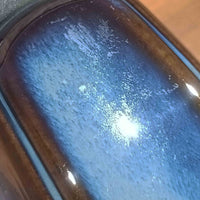 Einar JohansenがSoholm Keramik（スーホルム・セラミック）のためにデザインしたモデル1031は、深みのあるブルーの釉薬と立体的な面取りが織りなす陰影が美しい陶磁器ベースが特徴で、上部のマットな質感との対比がモダンで彫刻的な存在感を放つ北欧ビンテージ品です。プリーツシェードを透ける柔らかな灯りが落ち着いた雰囲気をつくり、ベッドサイドやリビングのアクセント照明として取り入れやすく、経年で深まった釉薬の表情が一点物ならではの魅力を一層引き立てています。