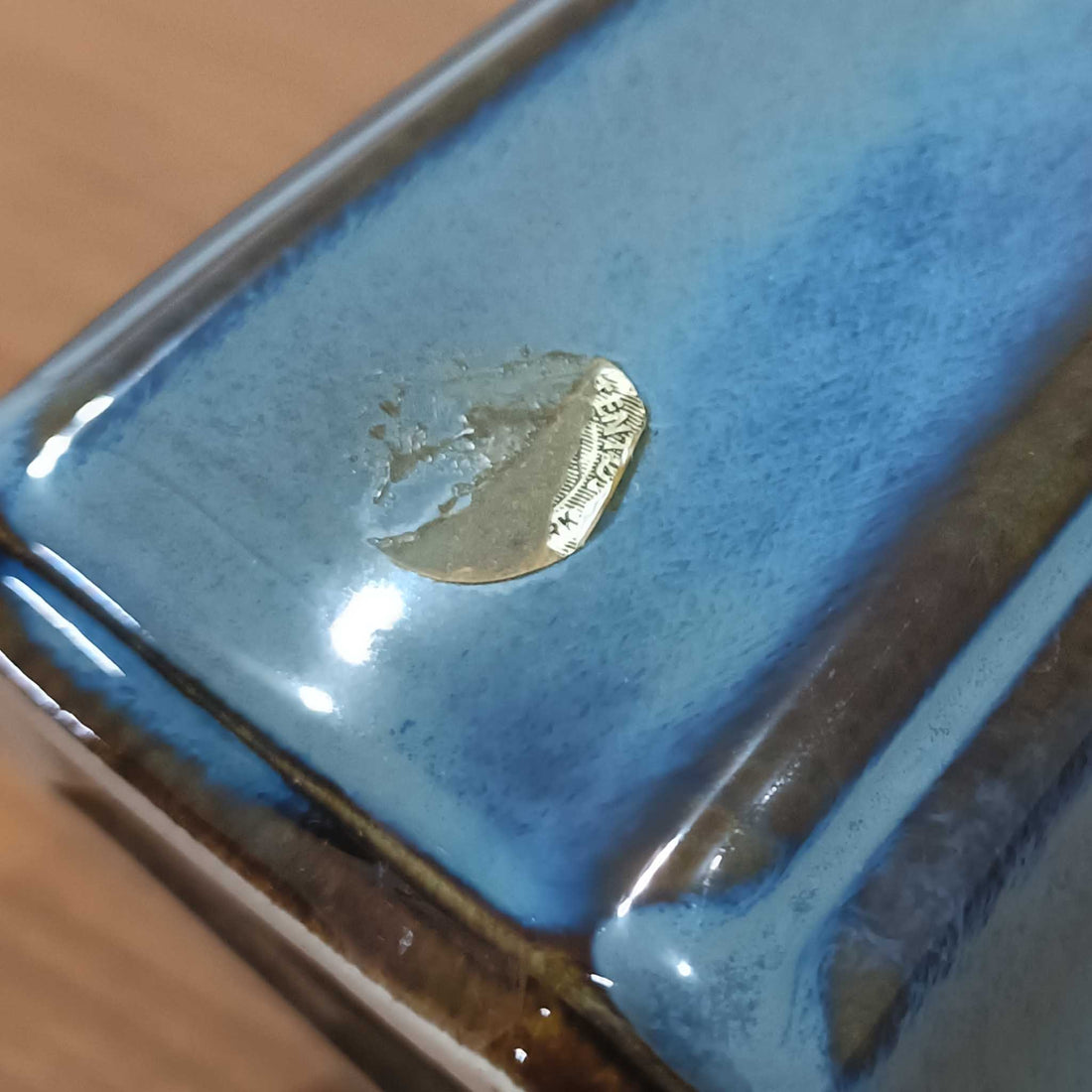 Einar JohansenがSoholm Keramik（スーホルム・セラミック）のためにデザインしたモデル1031は、深みのあるブルーの釉薬と立体的な面取りが織りなす陰影が美しい陶磁器ベースが特徴で、上部のマットな質感との対比がモダンで彫刻的な存在感を放つ北欧ビンテージ品です。プリーツシェードを透ける柔らかな灯りが落ち着いた雰囲気をつくり、ベッドサイドやリビングのアクセント照明として取り入れやすく、経年で深まった釉薬の表情が一点物ならではの魅力を一層引き立てています。