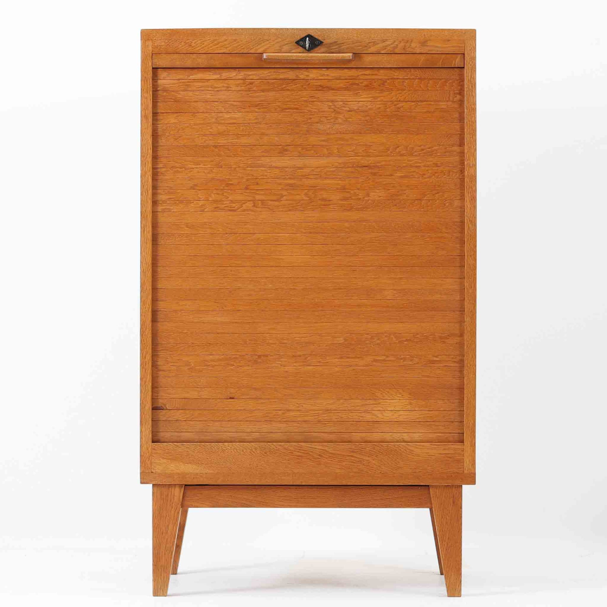 デンマーク製のオーク材蛇腹キャビネットです。直線的で無駄のないフォルムと、温かみのある木目が北欧らしい落ち着いた雰囲気を演出します。前面にはスペースを取らずに開閉できる蛇腹扉を採用し、内部には可動棚を備えることで収納する物に合わせて柔軟にレイアウトが可能。細身のテーパー脚により軽やかな印象を与えつつ、実用性とデザイン性を兼ね備えた一台で、リビングや書斎、寝室など幅広い空間で活躍します。ビンテージならではの素材の味わいが、空間に上質なアクセントを添えるアイテムです。