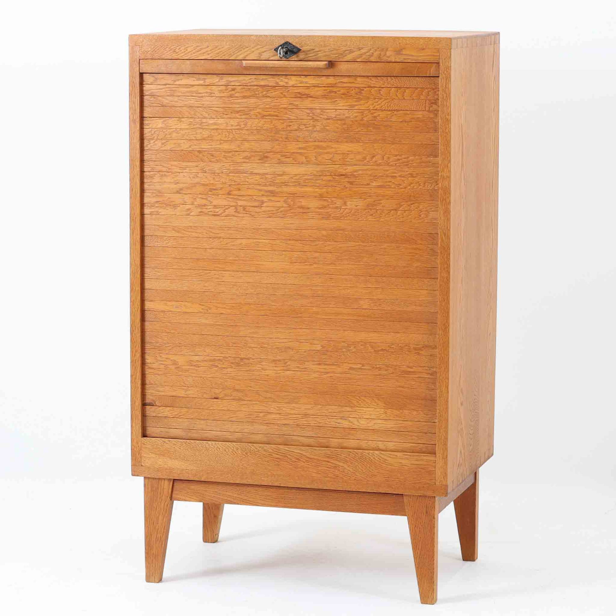 デンマーク製のオーク材蛇腹キャビネットです。直線的で無駄のないフォルムと、温かみのある木目が北欧らしい落ち着いた雰囲気を演出します。前面にはスペースを取らずに開閉できる蛇腹扉を採用し、内部には可動棚を備えることで収納する物に合わせて柔軟にレイアウトが可能。細身のテーパー脚により軽やかな印象を与えつつ、実用性とデザイン性を兼ね備えた一台で、リビングや書斎、寝室など幅広い空間で活躍します。ビンテージならではの素材の味わいが、空間に上質なアクセントを添えるアイテムです。