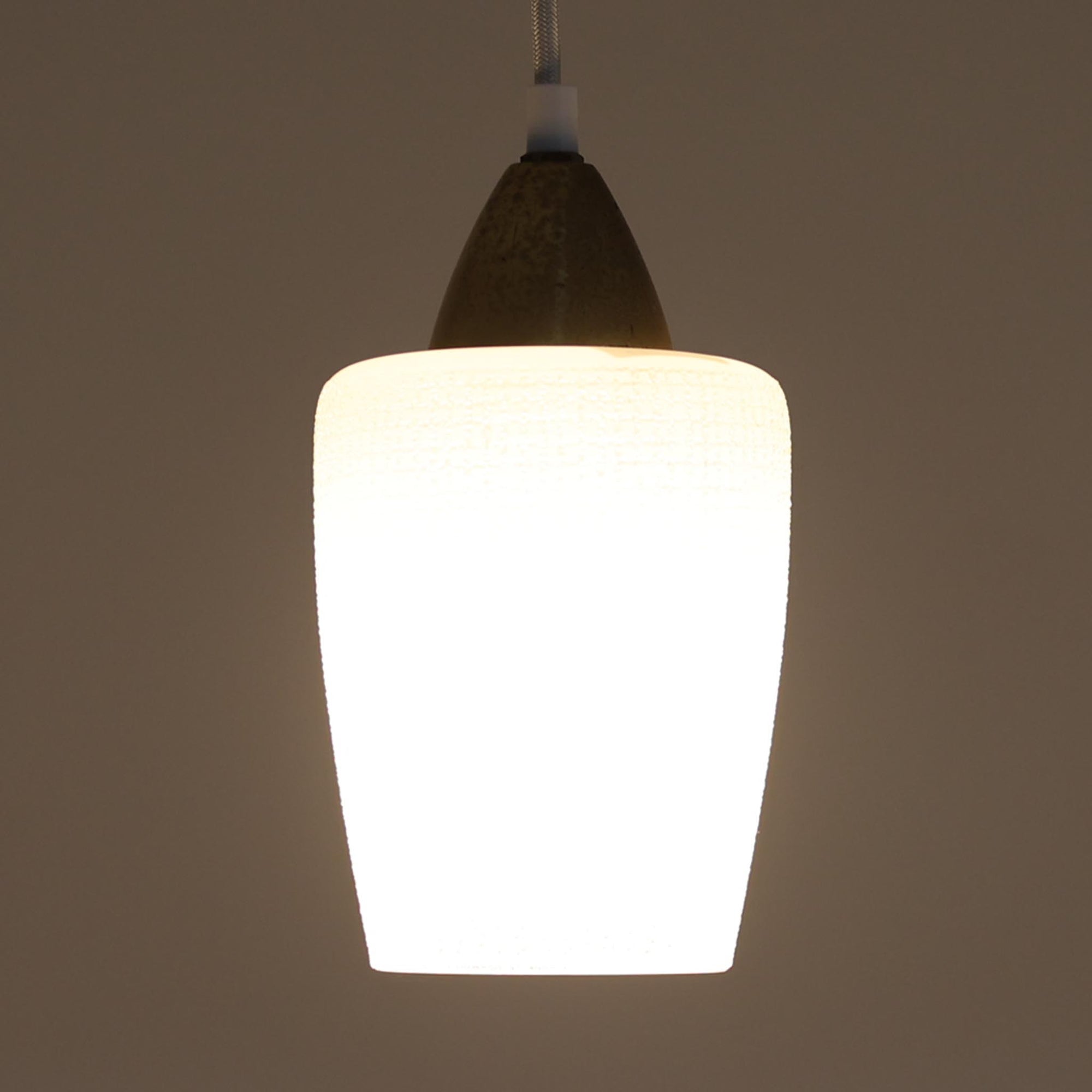 繊細なテクスチャーが施されたガラスシェードと、上部にあしらわれた真鍮パーツが上品に調和した直径11cmの小ぶりなペンダントライトで、柔らかい光がガラス越しに拡散し、空間に温かみのある雰囲気をもたらす北欧ビンテージ品です。控えめなサイズながら経年で深まった真鍮の風合いが個性を引き立て、玄関や洗面、キッチンカウンターなど小空間のアクセント照明として取り入れやすいデザインとなっています。クラフト感のあるガラスの質感が灯りに心地よい揺らぎを生み、単体でも複数灯でも美しくコーディネートできる点も魅力です。