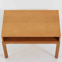 デンマークのデザイナー、カイ・クリスチャンセンによるデザイン、Aksel Kjersgaard社製のサイドテーブル「No.383」です。オーク材を用いた端正な造りで、脚部の滑らかなカーブや接合部の美しいラインなど、北欧家具の職人技が随所に感じられます。天板下には小物を収納できるスペースが設けられ、実用性とデザイン性を兼ね備えた構造です。経年によるオークの柔らかな風合いが魅力で、ベッドサイドやリビングのアクセントとしてもおすすめの一台です。