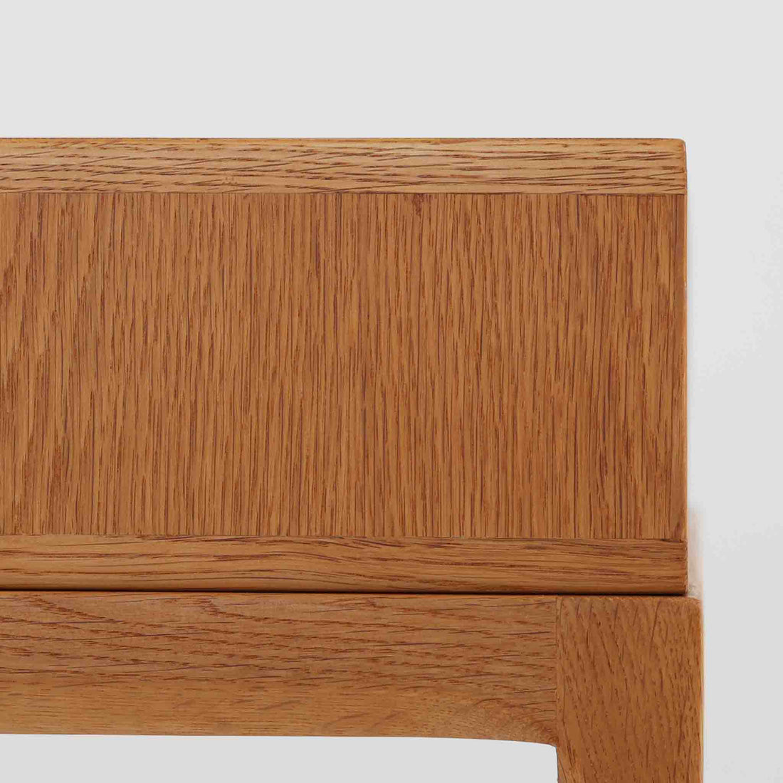 デンマークのデザイナー、カイ・クリスチャンセンによるデザイン、Aksel Kjersgaard社製のサイドテーブル「No.383」です。オーク材を用いた端正な造りで、脚部の滑らかなカーブや接合部の美しいラインなど、北欧家具の職人技が随所に感じられます。天板下には小物を収納できるスペースが設けられ、実用性とデザイン性を兼ね備えた構造です。経年によるオークの柔らかな風合いが魅力で、ベッドサイドやリビングのアクセントとしてもおすすめの一台です。