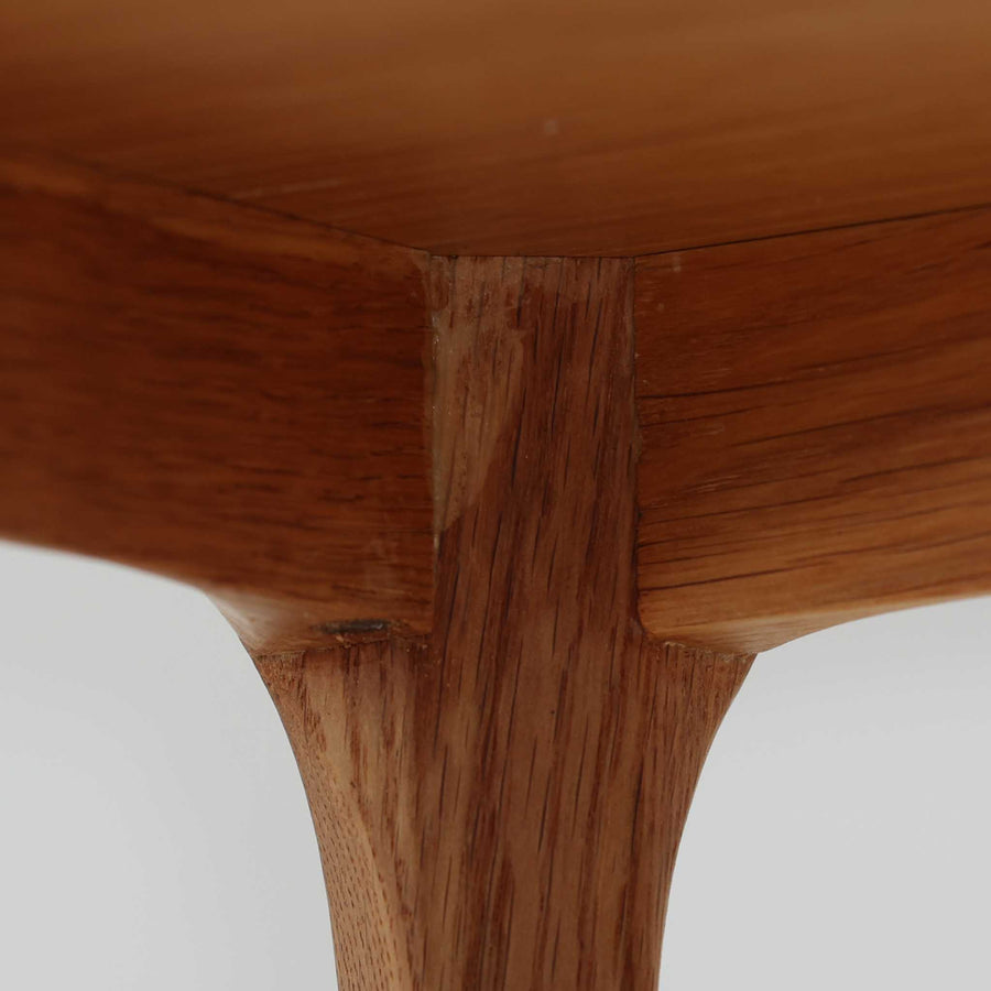 デンマークのデザイナー、カイ・クリスチャンセンによるデザイン、Aksel Kjersgaard社製のサイドテーブル「No.383」です。オーク材を用いた端正な造りで、脚部の滑らかなカーブや接合部の美しいラインなど、北欧家具の職人技が随所に感じられます。天板下には小物を収納できるスペースが設けられ、実用性とデザイン性を兼ね備えた構造です。経年によるオークの柔らかな風合いが魅力で、ベッドサイドやリビングのアクセントとしてもおすすめの一台です。