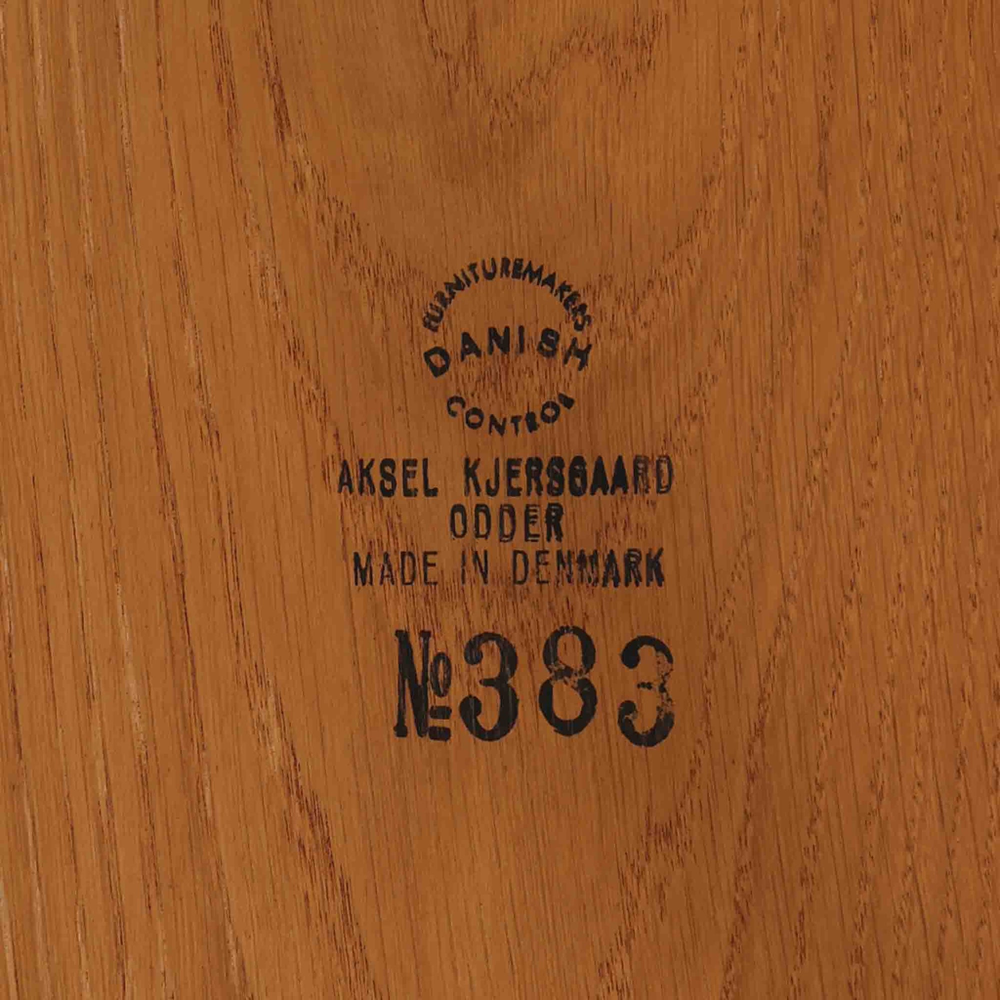 デンマークのデザイナー、カイ・クリスチャンセンによるデザイン、Aksel Kjersgaard社製のサイドテーブル「No.383」です。オーク材を用いた端正な造りで、脚部の滑らかなカーブや接合部の美しいラインなど、北欧家具の職人技が随所に感じられます。天板下には小物を収納できるスペースが設けられ、実用性とデザイン性を兼ね備えた構造です。経年によるオークの柔らかな風合いが魅力で、ベッドサイドやリビングのアクセントとしてもおすすめの一台です。