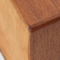 デンマーク製のサイドチェストで、シンプルなボックス構成にチーク材の豊かな風合いが映える北欧ビンテージらしい一台です。オープンスペースは本や小物の収納に便利で、引き出しには金属フレームを組み合わせたユニークな取手がアクセントとして効いています。丸みを帯びた角や細く伸びたテーパードレッグが軽快な印象を与え、ベッドサイドやソファ横でのサイドテーブル使いにも最適。経年変化の味わい深い木肌が空間に温かさと上質さを添えます。