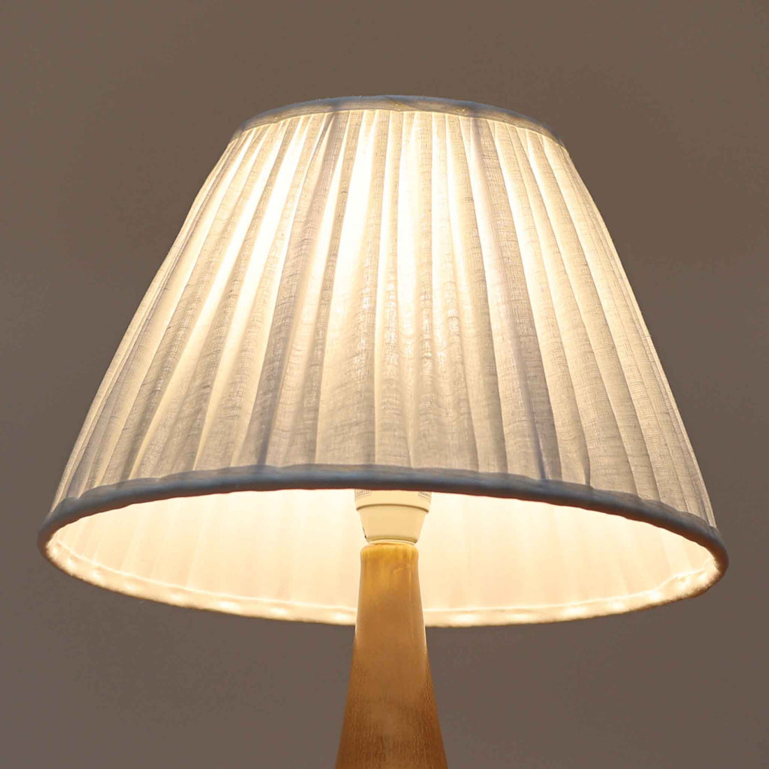 Per Lindemann SchmidtがPalshusのために手掛けたモデル「PL-5 SL 2」は、均整の取れたシルエットと滑らかに焼き締められたマットブラウンの陶肌が静かな存在感を放つテーブルランプで、首元にほんのり入る明るい釉薬のグラデーションが柔らかな表情を添える北欧ビンテージ品です。プリーツシェード越しに広がる落ち着いた灯りはリビングやベッドサイドに心地よい温もりをもたらし、シンプルながら洗練された造形美と経年で深まった風合いを長く楽しめる一台です。