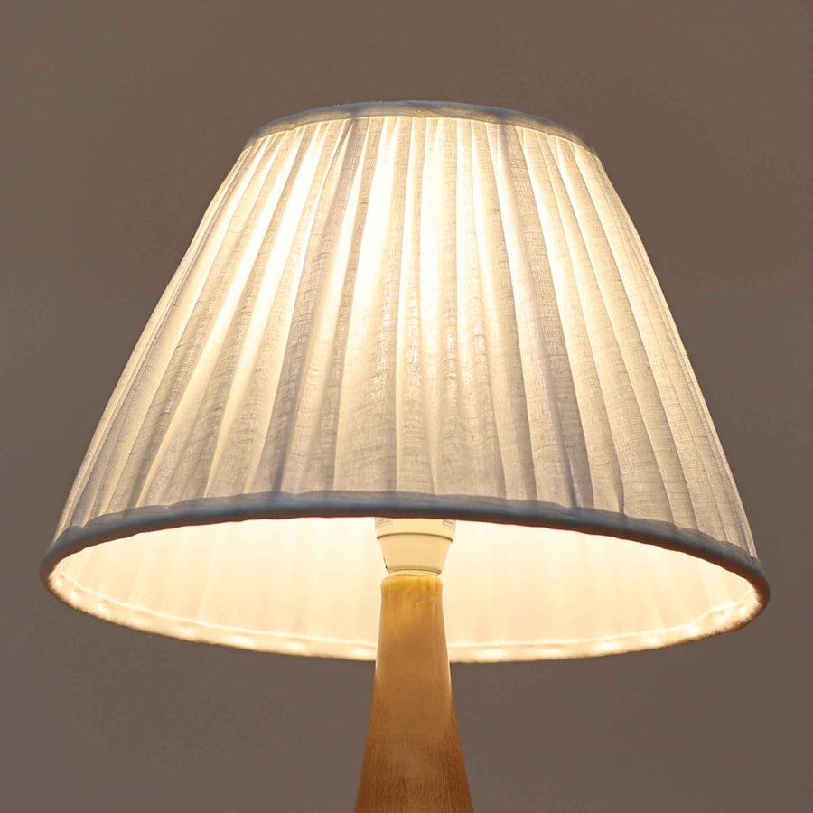 Per Lindemann SchmidtがPalshusのために手掛けたモデル「PL-5 SL 2」は、均整の取れたシルエットと滑らかに焼き締められたマットブラウンの陶肌が静かな存在感を放つテーブルランプで、首元にほんのり入る明るい釉薬のグラデーションが柔らかな表情を添える北欧ビンテージ品です。プリーツシェード越しに広がる落ち着いた灯りはリビングやベッドサイドに心地よい温もりをもたらし、シンプルながら洗練された造形美と経年で深まった風合いを長く楽しめる一台です。