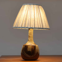 Axella製のこちらのテーブルランプは、素地を生かした陶土の質感に流れるような釉薬のグラデーションが重なり合う有機的な表情が魅力で、ぽってりとした丸みのあるフォルムと細く立ち上がる首部の対比が北欧らしい温かみのある佇まいを生み出すビンテージ品です。手仕事ならではの不均一な釉薬の景色が一点物の存在感を与え、リネンシェードからこぼれる柔らかな灯りがリビングや寝室に落ち着いた雰囲気を添え、経年で深まった陶肌の風合いが空間に自然なアクセントを加えてくれます。