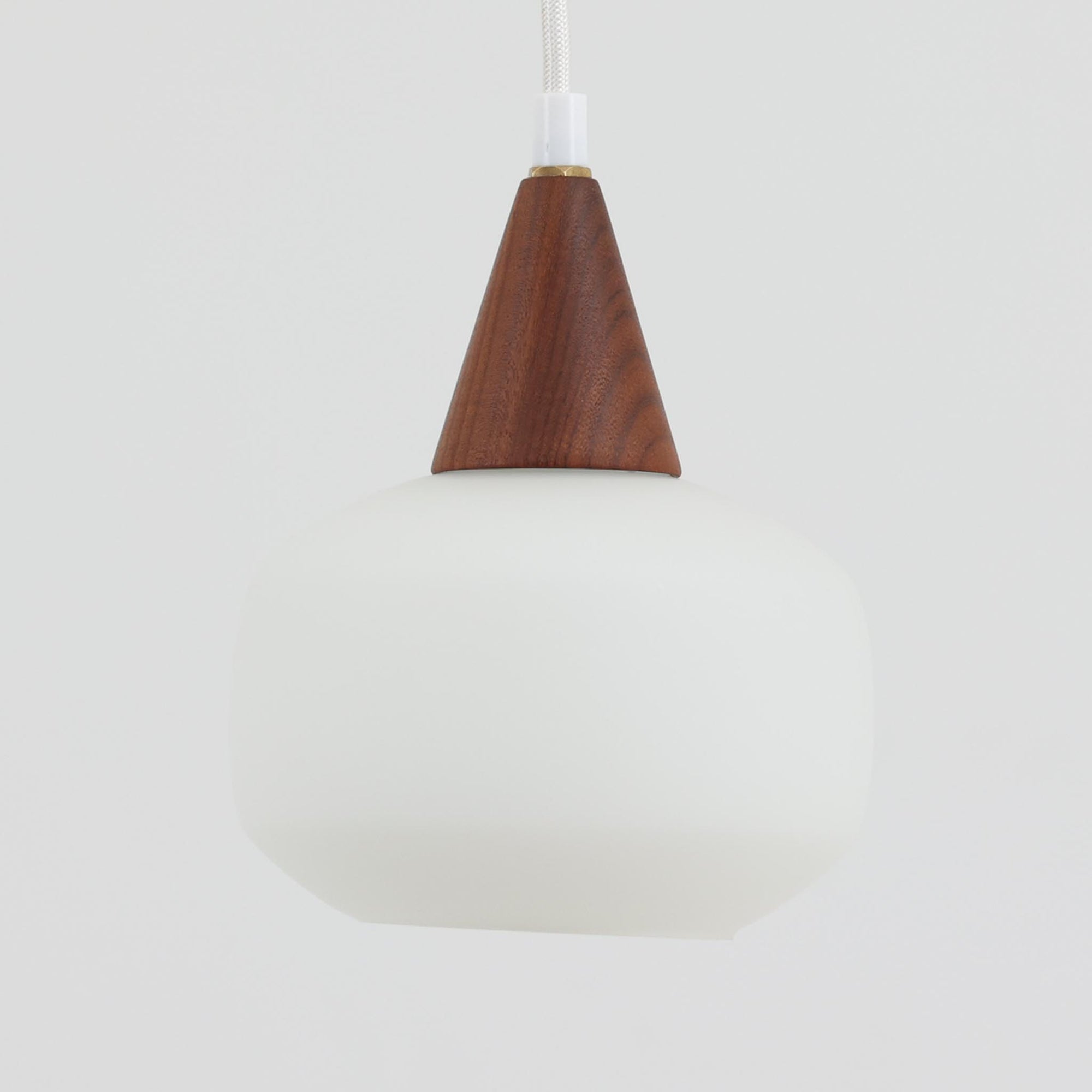 丸みを帯びた乳白ガラスシェードに温かみのあるウッドパーツを組み合わせた直径14cmのペンダントライトで、柔らかい光がふんわりと広がり、小空間に落ち着いた表情をもたらす北欧ビンテージ品です。シンプルながらもコロンとした可愛らしいフォルムがアクセントとなり、玄関や廊下、キッチンカウンターなど限られたスペースにも取り入れやすいサイズ感が魅力です。ガラス越しの柔らかな光とウッドの自然な表情が調和し、経年で深まった素材の風合いがビンテージならではの温もりを感じさせてくれます。