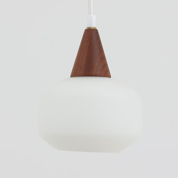 丸みを帯びた乳白ガラスシェードに温かみのあるウッドパーツを組み合わせた直径14cmのペンダントライトで、柔らかい光がふんわりと広がり、小空間に落ち着いた表情をもたらす北欧ビンテージ品です。シンプルながらもコロンとした可愛らしいフォルムがアクセントとなり、玄関や廊下、キッチンカウンターなど限られたスペースにも取り入れやすいサイズ感が魅力です。ガラス越しの柔らかな光とウッドの自然な表情が調和し、経年で深まった素材の風合いがビンテージならではの温もりを感じさせてくれます。