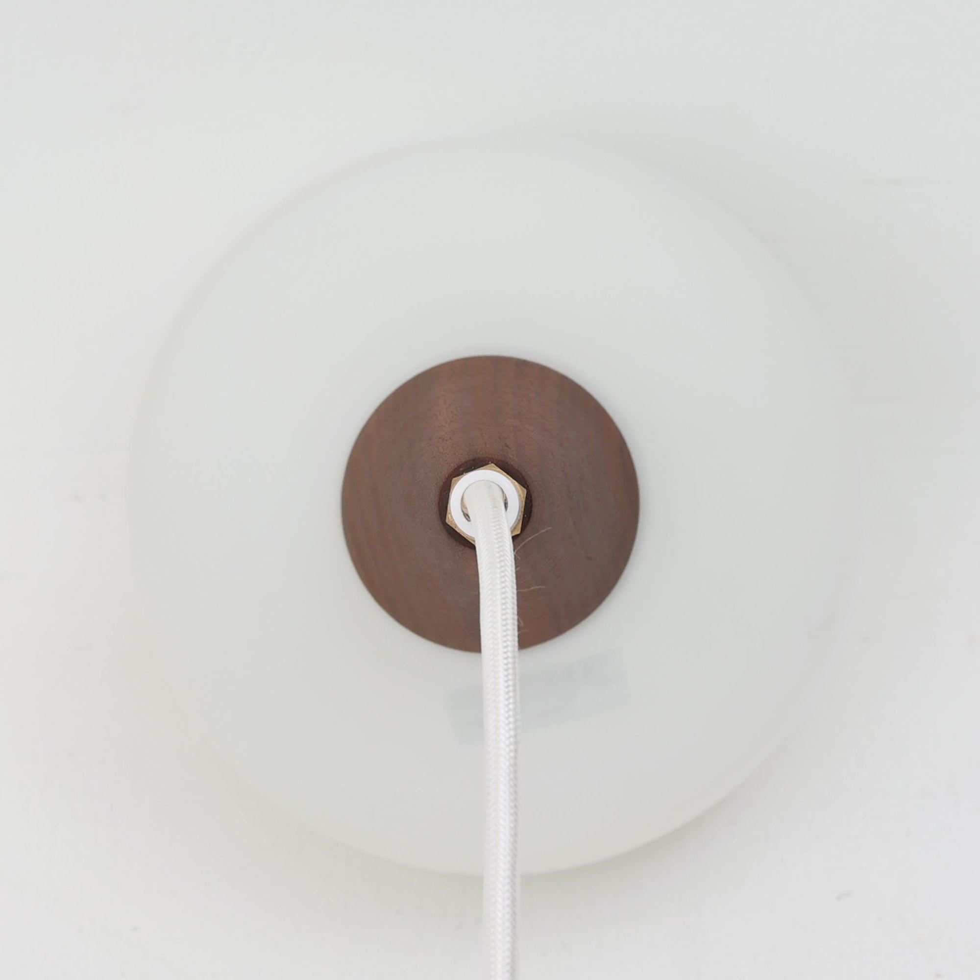 丸みを帯びた乳白ガラスシェードに温かみのあるウッドパーツを組み合わせた直径14cmのペンダントライトで、柔らかい光がふんわりと広がり、小空間に落ち着いた表情をもたらす北欧ビンテージ品です。シンプルながらもコロンとした可愛らしいフォルムがアクセントとなり、玄関や廊下、キッチンカウンターなど限られたスペースにも取り入れやすいサイズ感が魅力です。ガラス越しの柔らかな光とウッドの自然な表情が調和し、経年で深まった素材の風合いがビンテージならではの温もりを感じさせてくれます。