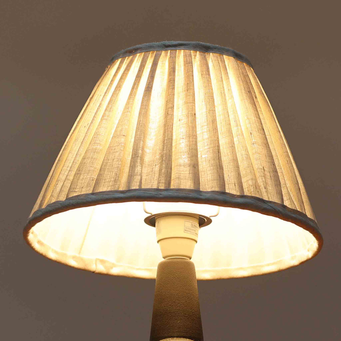 Einar JohansenがSoholm Keramikのために手掛けたモデル「1052」は、濃淡のある深いブルーグラデーションと面取りを施した立体的なフォルムが美しく、上部のマットな質感とのコントラストが上品な存在感を生む北欧ビンテージのテーブルランプです。柔らかく広がるリネンシェードの灯りが陰影豊かな陶肌をやさしく照らし、リビングや寝室のアクセントとして取り入れやすく、経年で深まった釉薬の表情が一点物ならではの味わいを引き立てています。