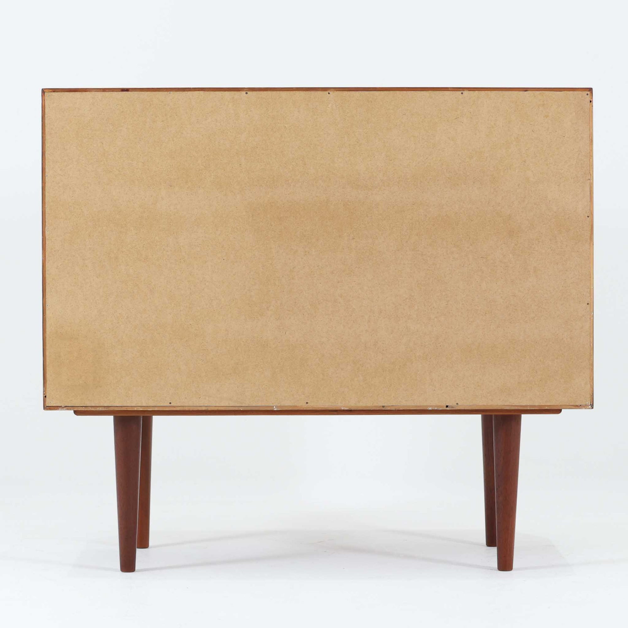 Kai Kristiansenがデザインし、Feldballes Mobelfabrikが製作した幅86cmの小ぶりなボードです。チーク材の美しい木目を活かした端正な箱型フォルムに、丸い引き手付きの引き戸がアクセントを添えます。内部には棚とトレー収納を備え、書類や小物を整理しやすい実用的な構造。すらりと伸びる脚部が軽やかさを演出し、限られた空間にも取り入れやすいサイズ感です。経年により深みを増した木肌が、北欧ビンテージならではの温もりと存在感を感じさせます。
