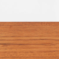 Kai Kristiansenがデザインし、Feldballes Mobelfabrikが製作した幅86cmの小ぶりなボードです。チーク材の美しい木目を活かした端正な箱型フォルムに、丸い引き手付きの引き戸がアクセントを添えます。内部には棚とトレー収納を備え、書類や小物を整理しやすい実用的な構造。すらりと伸びる脚部が軽やかさを演出し、限られた空間にも取り入れやすいサイズ感です。経年により深みを増した木肌が、北欧ビンテージならではの温もりと存在感を感じさせます。