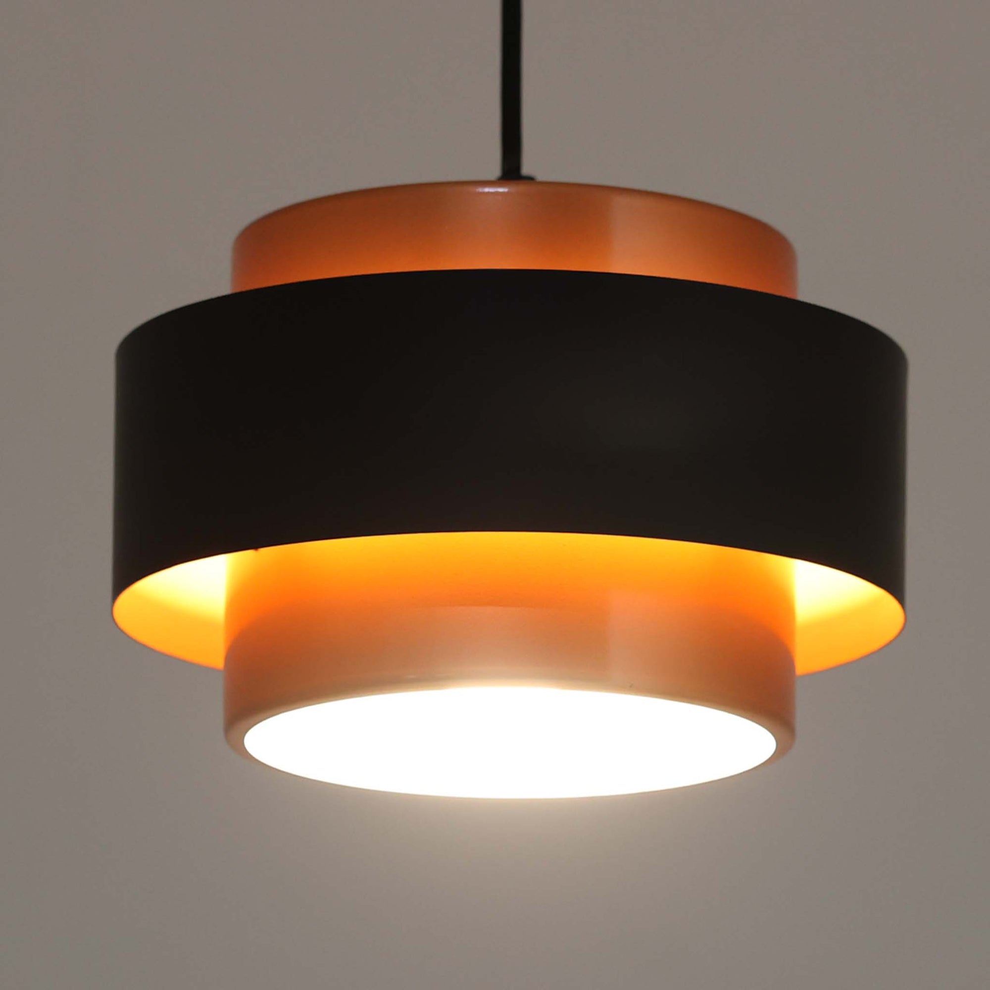 Jo HammerborgがFog &amp; Morupのためにデザインした「Juno」は、直径24cmの扱いやすいサイズに、銅色のシェードとマットブラックのバンドを組み合わせた構築的なフォルムが印象的なスチール製ペンダントライトで、点灯時には上下から柔らかく光が漏れ、空間に落ち着いた陰影を生み出す北欧ビンテージ品です。ハーマボーらしいミニマルで彫刻的な造形が存在感を放ち、ダイニングやリビング、カウンター上のアクセント照明としても取り入れやすく、経年で深まった金属の質感がビンテージならではの魅力を一層引き立てています。