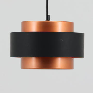 Jo HammerborgがFog & Morupのためにデザインした「Juno」は、直径24cmの扱いやすいサイズに、銅色のシェードとマットブラックのバンドを組み合わせた構築的なフォルムが印象的なスチール製ペンダントライトで、点灯時には上下から柔らかく光が漏れ、空間に落ち着いた陰影を生み出す北欧ビンテージ品です。ハーマボーらしいミニマルで彫刻的な造形が存在感を放ち、ダイニングやリビング、カウンター上のアクセント照明としても取り入れやすく、経年で深まった金属の質感がビンテージならではの魅力を一層引き立てています。